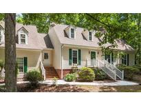 Charming home with green shutters, dormer windows, and a brick walkway leading to the inviting entrance at 63 Tally Ho Dr, Selma, NC 27576