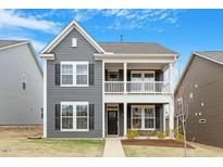 Charming two-story home with a quaint front porch and well-maintained lawn offers great curb appeal at 813 James J Freeland Dr, Hillsborough, NC 27278