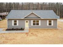 Charming single-story home with gray siding, white trim, and a bright yellow front door at 100 Gates St, Roxboro, NC 27573