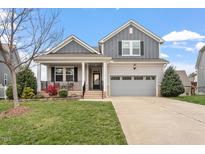 Charming two-story home with a well-manicured lawn, attached garage, and inviting front porch at 1020 Topland Ct, Morrisville, NC 27560