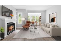 Bright living room featuring a fireplace, large windows, and space for a home office setup at 1300 Hillbrow Ln # 204, Raleigh, NC 27615