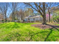 Charming single-story home with well-maintained lawn and mature trees at 140 Hedgerow, Pittsboro, NC 27312