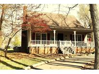 Charming single-story home featuring a cozy front porch and manicured landscaping with trees in a residential neighborhood at 1409 Keogh St, Burlington, NC 27215