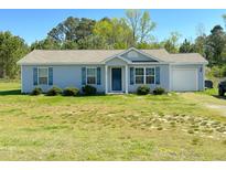Charming single-story home with blue shutters, a front yard, and an attached garage at 15 Golden Poppy Ln, Youngsville, NC 27596