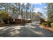 Charming brick home with an attached two-car garage surrounded by mature trees and professional landscaping at 1965 Wedgewood Dr, Sanford, NC 27332