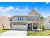 Charming two-story home with a front-entry garage and manicured lawn at 245 Naples Ln, Clayton, NC 27527