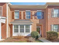 Brick townhome with brown shutters, bay window, and a welcoming front entrance with a wreath decor at 2728 Cloud Mist Cir, Raleigh, NC 27614