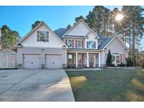 Inviting two-story home features a two-car garage, manicured lawn, and a covered front porch with stone accents at 286 Sea Mist Dr, Sanford, NC 27332