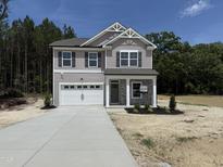 Charming two-story home featuring gray siding, stone accents, a front-entry two car garage, and concrete driveway at 4012 Kingcraig Ln, Zebulon, NC 27597