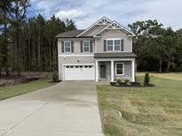 Charming two-story home featuring a two-car garage, stone accents, and a well-manicured lawn at 4012 Kingcraig Ln, Zebulon, NC 27597