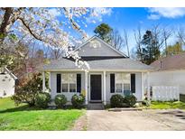 Charming single-story home with blossoming tree, well-kept lawn, and inviting entryway at 4118 Sudbury Rd, Durham, NC 27704