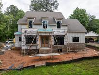 New construction shows a two-story home with brick base and ladder access points on a muddy lot at 5107 Hearth Dr, Raleigh, NC 27609