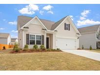 Charming two-story home with manicured lawn and attached two-car garage at 5205 Sorrell Glen Dr, Raleigh, NC 27603