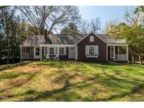 Charming home with a well-manicured lawn, inviting facade, and a cozy porch with outdoor seating at 55 Lindsey St, Pittsboro, NC 27312