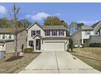 Charming two-story home with a two-car garage, well-manicured lawn, and classic architectural details at 106 Canvasback Dr, Durham, NC 27704