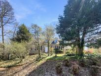 Charming home exterior featuring neutral paint, a well-manicured front yard, and mature trees at 112 Old Bridge Ln, Chapel Hill, NC 27517