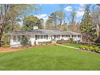 Charming ranch home with a well-manicured lawn and mature trees, providing excellent curb appeal at 1417 Hathaway Rd, Raleigh, NC 27608