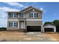 New two-story home with neutral siding, double hung windows, and two car garage on a sunny day at 15 Atherton Circle, Angier, NC 27501