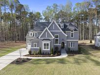 Stunning two-story home featuring a manicured lawn and traditional architectural details at 1520 Lake Adventure Ct, Raleigh, NC 27613