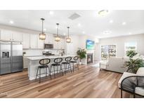 Bright, open-concept kitchen with white cabinets, stainless steel appliances, and a large island with bar seating at 1613 Clayfire Dr, Cary, NC 27519