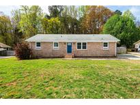 Charming brick home with a well-maintained lawn and a welcoming blue front door at 229 Tracy Trl, Durham, NC 27712