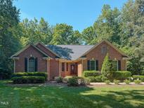 Charming brick home with manicured landscaping and mature trees at 2440 Helena Moriah Rd, Timberlake, NC 27583