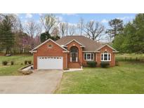 Lovely brick home with an attached garage and lush lawn at 2563 Millbrook Dr, Haw River, NC 27258