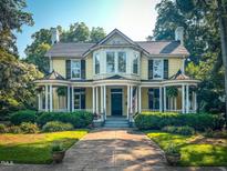 Charming yellow two-story home with manicured lawn and inviting front porch at 308 College St, Oxford, NC 27565