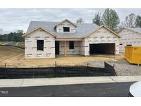 Unfinished home exterior shows construction with wrapped walls and framed windows, ready for customization at 312 Providence Creek Dr, Fuquay Varina, NC 27526