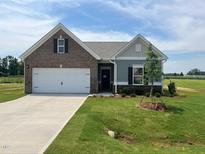 Charming single-story home showcasing a brick and siding exterior with well-manicured lawn at 34 E American Marigold Dr # 64, Benson, NC 27504
