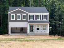 Two-story home with a gray roof, vinyl siding, an attached garage, and a covered front porch under construction at 46 Atherton Circle, Angier, NC 27501
