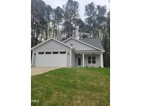 Charming single-story home featuring a two car garage and well-manicured lawn at 5710 Russell Rd, Durham, NC 27712