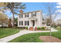 Charming two-story home featuring a brick chimney, black shutters, and landscaped front yard at 5900 Brushwood Ct, Raleigh, NC 27612