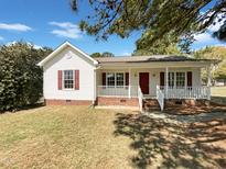 Charming single-story home with a cozy front porch and brick foundation details at 5908 O C Hester Rd, Holly Springs, NC 27540