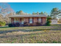 Charming brick ranch-style home with a well-maintained lawn and detached garage at 604 Orange Factory Road, Bahama, NC 27503
