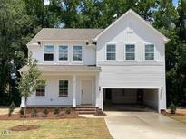 Charming two-story home featuring a welcoming front porch, attached garage and manicured front yard with mature tree at 61 Atherton Circle, Angier, NC 27501