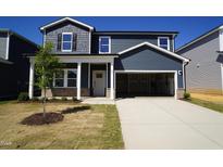 Charming two-story home featuring a spacious two-car garage, a welcoming front porch, and manicured lawn at 621 White Birch Ln, Angier, NC 27501