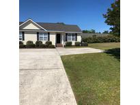 Inviting one-story home with a well-manicured front yard and driveway, nestled under a clear blue sky at 70 Ariel St, Lillington, NC 27546