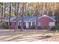 Charming one-story brick home featuring mature trees and a well-maintained lawn at 711 Evergreen Rd, Rocky Mount, NC 27803