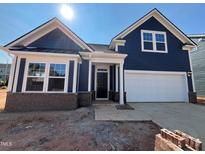 Charming new construction home with a blue exterior, brick foundation, and a two car garage at 771 Old Station Pointe, Angier, NC 27501