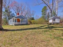 Charming cottage-style home with blue siding, white trim, covered porch and spacious yard at 774 Cornelius St, Hillsborough, NC 27278