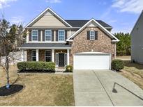 Charming two-story home featuring a brick facade, attached two-car garage, and a beautifully landscaped front yard at 103 Glenview Ln, Durham, NC 27703