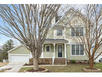 Charming two-story home with manicured lawn, welcoming porch, and attached two-car garage at 104 Low Country Ct, Morrisville, NC 27560