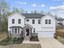 Charming two-story home boasts white siding, stone accents, well-manicured landscaping, and an attached two-car garage at 111 Kim Bark Path, Garner, NC 27529
