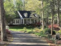 Charming home with a welcoming front porch, manicured lawn, and mature trees at 1229 Westerham Dr, Wake Forest, NC 27587