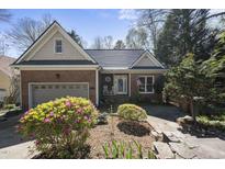 Charming brick home featuring a well-manicured lawn, an attached garage, and a cozy front porch at 155 Chimney Rise Dr, Cary, NC 27511