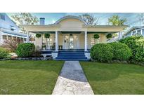 Charming home featuring a lovely front porch, lush landscaping, and inviting curb appeal at 211 W Chisholm St, Sanford, NC 27330