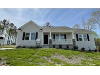 Charming single-story home featuring a covered front porch and professionally landscaped yard at 279 Constellation Ct, Benson, NC 27504