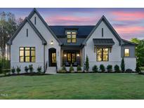 Charming exterior of a white painted brick home with gray accents and a well-manicured lawn at twilight at 2809 Theresa Eileen Way, Raleigh, NC 27603