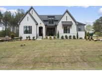A stunning, newly built two-story home featuring a white brick facade and a freshly laid lawn at 2809 Theresa Eileen Way, Raleigh, NC 27603